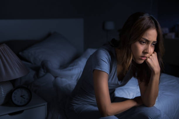 istock Depressed young Asian woman sitting in bed cannot sleep from insomnia 1289303586