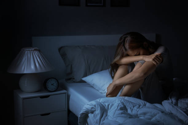 istock Depressed young Asian woman sitting in bed cannot sleep from insomnia 1289303606