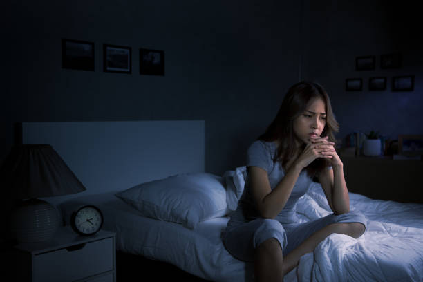 istock Depressed young Asian woman sitting in bed cannot sleep from insomnia 1289303611