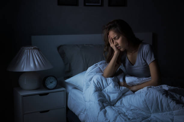 istock Depressed young Asian woman sitting in bed cannot sleep from insomnia 1289303625