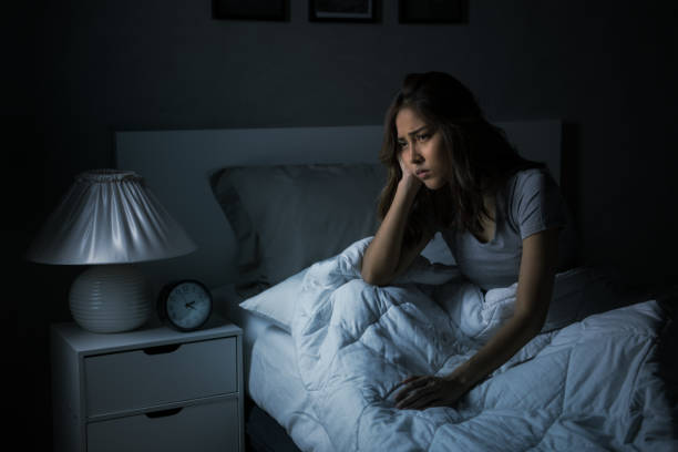 Depressed young Asian woman sitting in bed cannot sleep from insomnia Depressed young Asian woman sitting in bed cannot sleep from insomnia waking up photos stock pictures, royalty-free photos & images