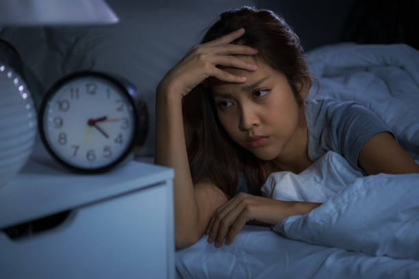 istock Depressed young woman lying in bed cannot sleep from insomnia 1289303658