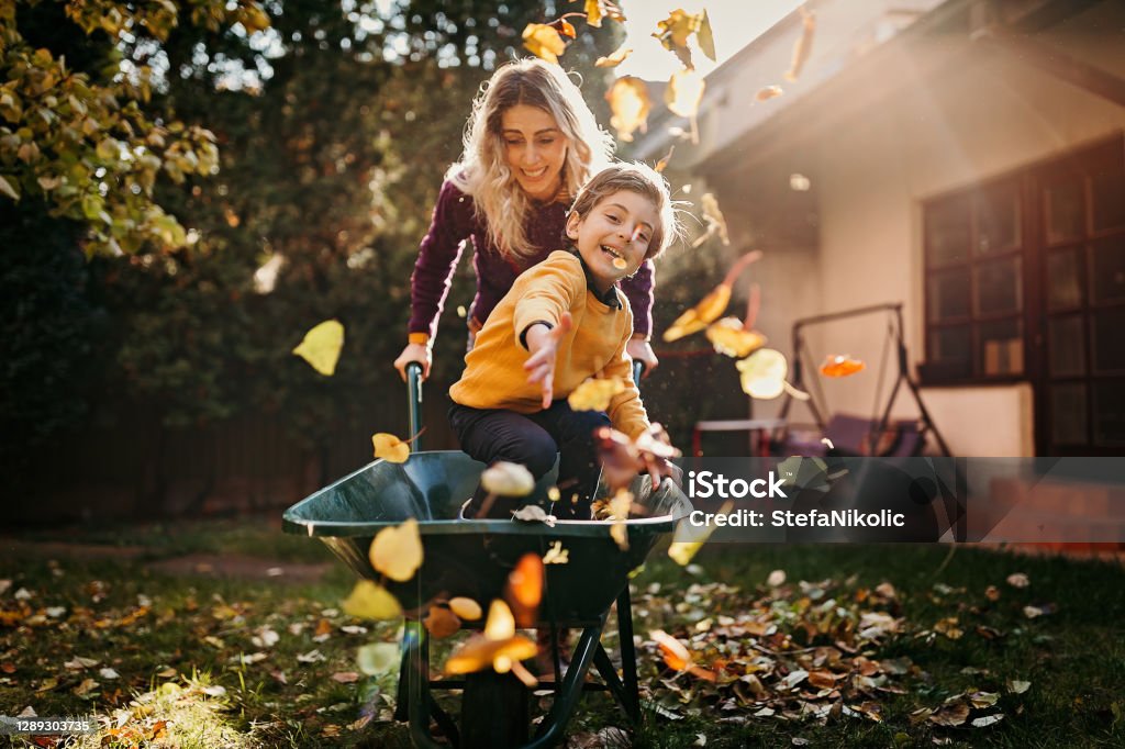 Crazy as always Mother and son playing in backyard with gardening equipment Autumn Stock Photo