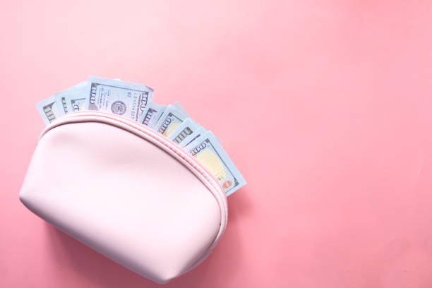 100 dollar cash in leather on pink background