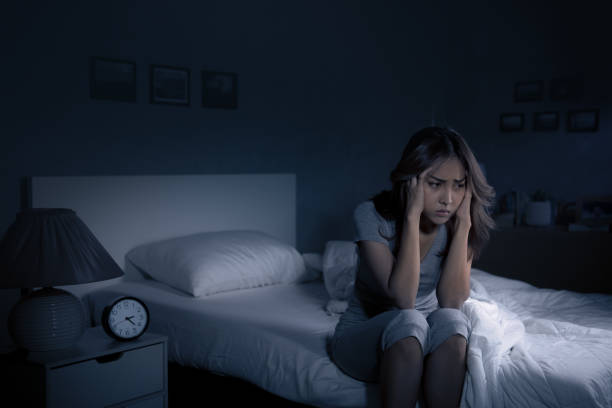 istock Depressed young Asian woman sitting in bed cannot sleep from insomnia 1289306281