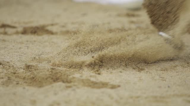 close up of golfer hitting the ball at sand bunker in slow motion