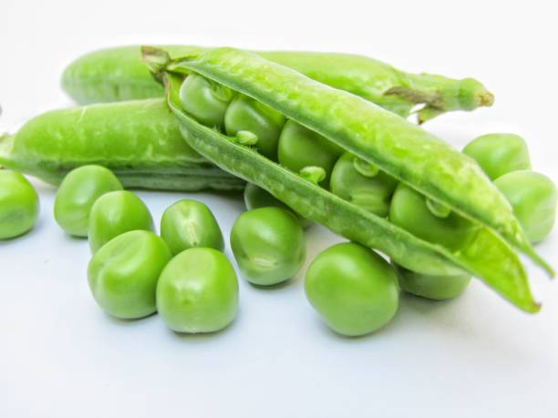 istock Fresh green peas isolated on white background 1289307109