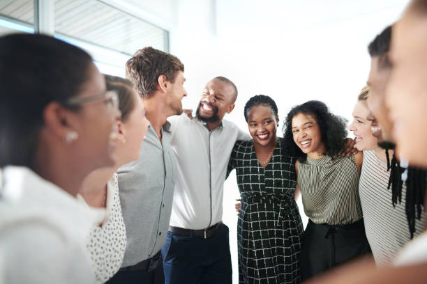 Joining forces to become the most successful team Shot of a group of businesspeople standing together in a huddle arm around stock pictures, royalty-free photos & images