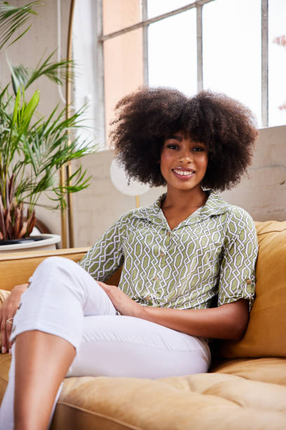 istock Young woman smiling while sitting at home on a sofa in the afternoon 1289314845