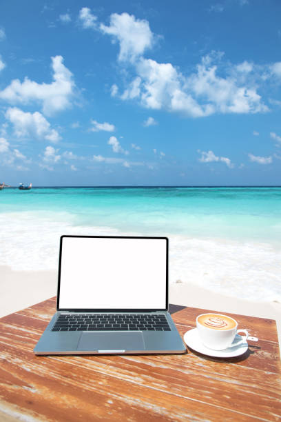 istock Mobile work office on the beach with blank laptop screen 1289315673