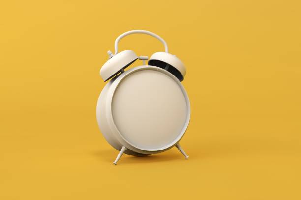 istock Old alarm clock on yellow background 1289318292
