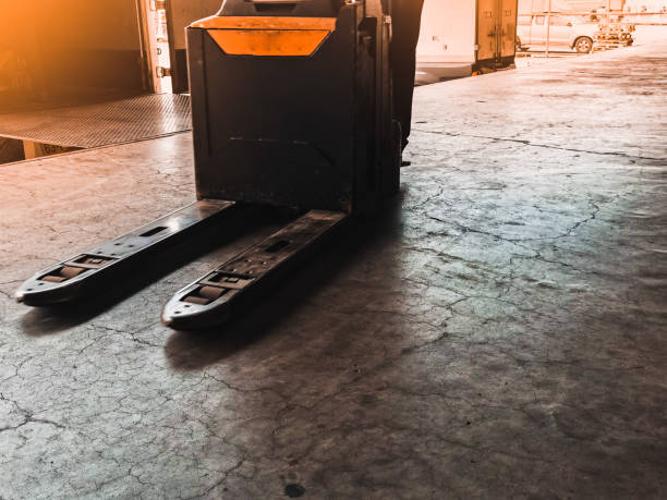 istock Worker driving forklift loading shipment carton boxes goods on wooden pallet at loading dock from container truck to warehouse cargo storage in freight logistics, transportation industrial, delivery 1289318306