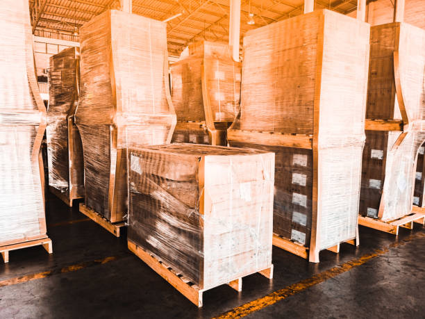 Worker driving forklift loading shipment carton boxes goods on wooden pallet at loading dock from container truck to warehouse cargo storage in freight logistics, transportation industrial, delivery trabajador conduciendo carretilla elevadora de carga cajas de cartón de mercancías en palet de madera en el muelle de carga desde el camión contenedor hasta el almacenamiento de carga de almacén en logística de carga, transporte industrial, entrega