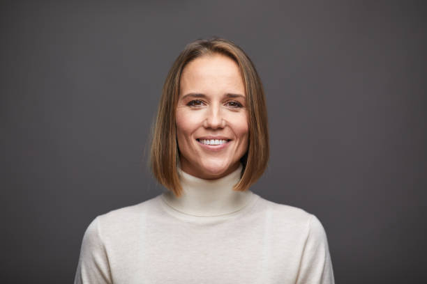 One woman looking at the camera and wearing a turtleneck sweater.