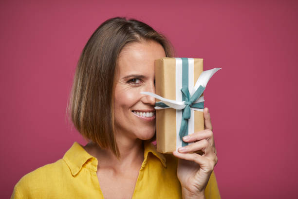 istock One woman covers her face with a Christmas gift. 1289321939