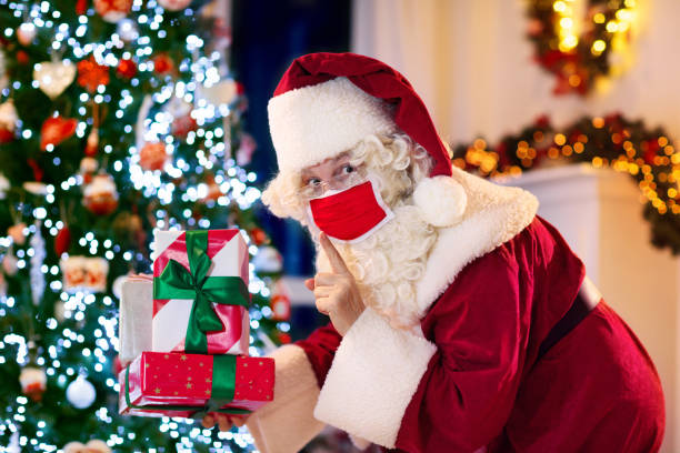 istock Santa in face mask at Christmas tree 1289322037