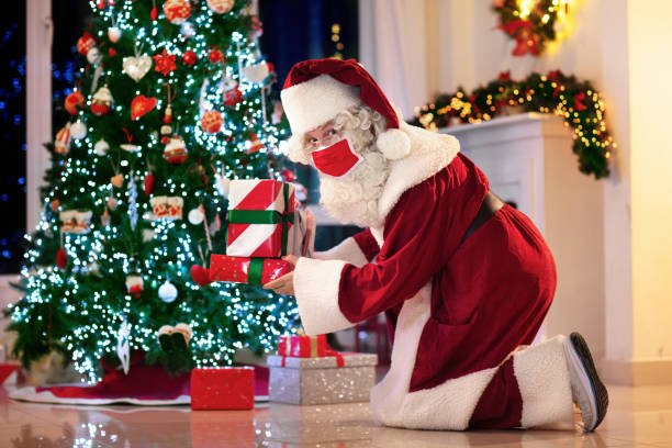 istock Santa in face mask at Christmas tree 1289322208