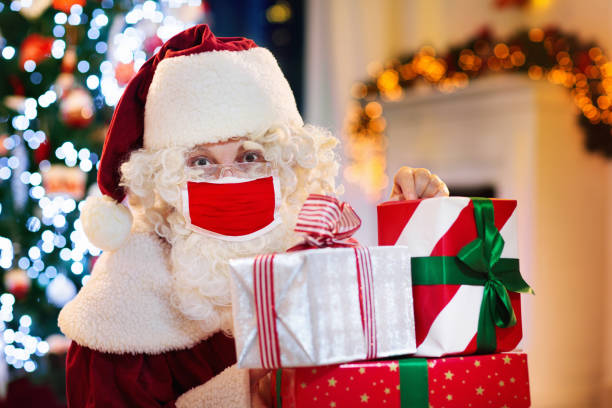 istock Santa in face mask at Christmas tree 1289322226