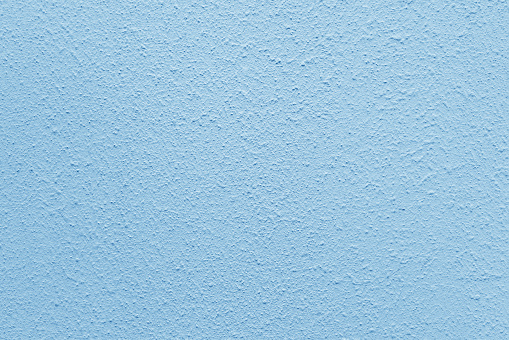 Light blue wall of the building. Rough plaster surface. Abstract background.