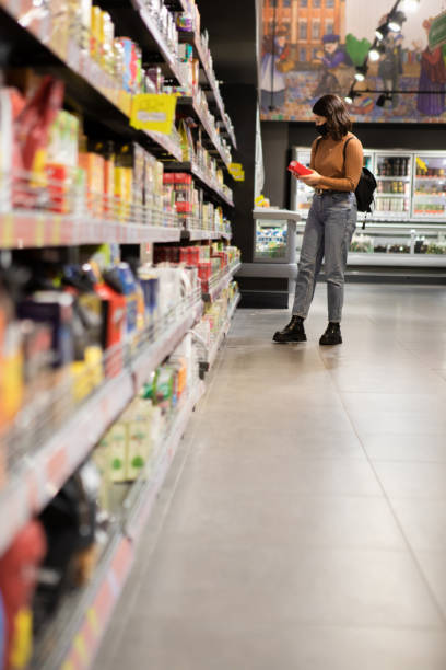 istock woman compare products at grocery store 1289328492