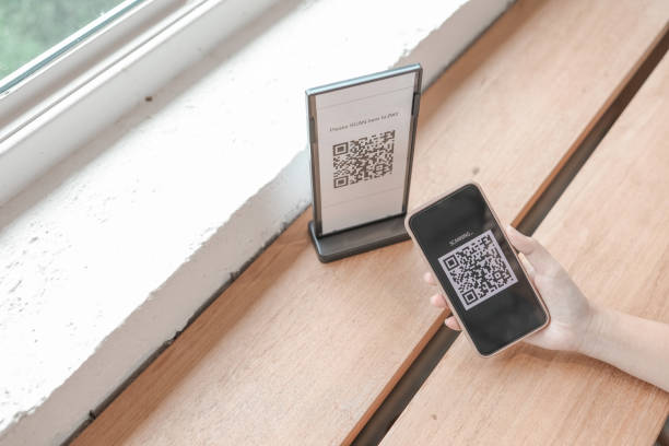istock E wallet Qr code payment. Woman scanning QR code online shopping cashless technology concept 1289331378