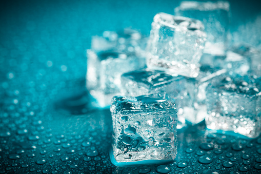 Square melting ice cubes on wet table
