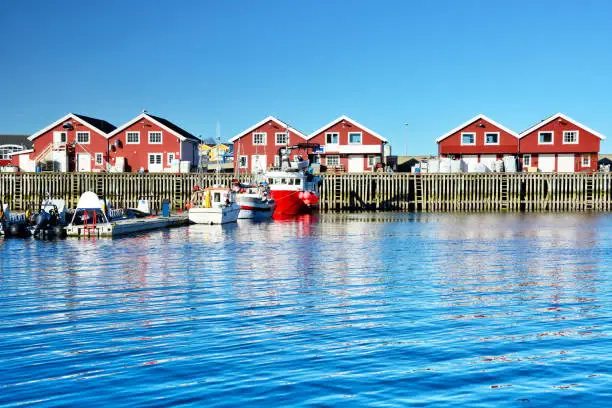 Red rorbu buildings in Bodo harbor, Norway. Composite photo