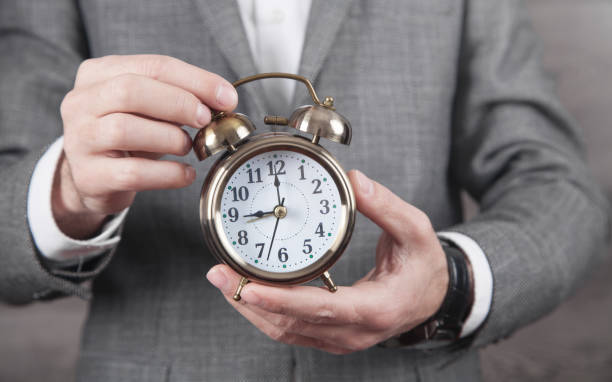 istock Caucasian businessman holding alarm clock. 1289340672