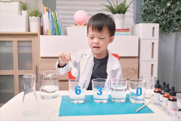 istock Little Asian kindergarten kid studying science, making Sugar Water Density Experiment, Kid-friendly fun and easy science experiments at home 1289341822
