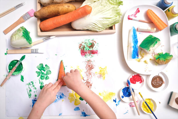 primo piano di mani bambino, bambino che realizza opere d'arte dalla timbratura di verdure a casa, arte divertente e artigianato per i più piccoli - preschooler preschool child painting foto e immagini stock