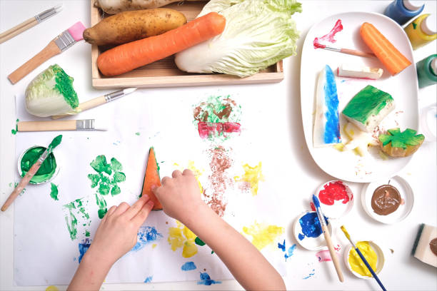 top view close up of toddler boy child hands, kid making artwork from vegetable stamping at home, fun art and crafts for toddlers - young potatoes imagens e fotografias de stock