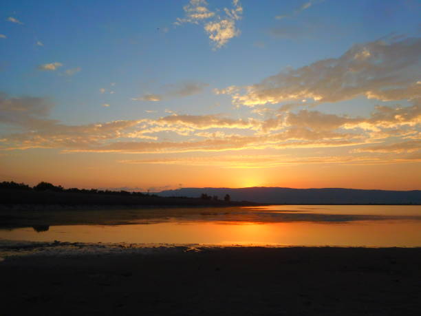 istock A perfect sunset. Golden colored cloudy sky horizon over lake waters. 1289342934