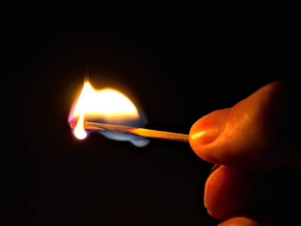 istock burning match and finger in front of black background 1289345336