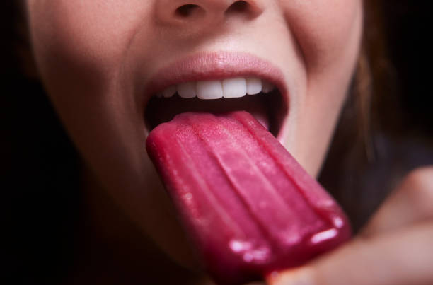 istock Young woman mouth eating popsicle ice cream 1289346465