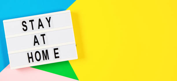istock Lightbox with text STAY AT HOME on yellow, green, pink and light blue background. Top view 1289347878