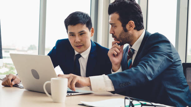 istock Two business people talk project strategy at office 1289348310