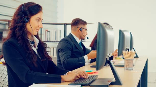 istock Business people wearing headset working in office 1289354382
