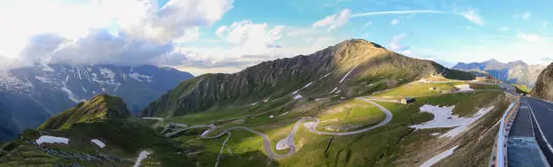 Panorama of Grossglockner High Alpine Road with approaching thunderstorm and sunset. The road trip is the highest surfaced mountain pass road in Austria. The view of Edelweispitz. Winding road.