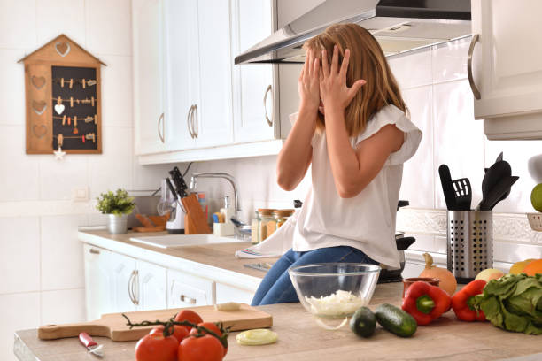 istock Girl on kitchen bench preparing food with hands on face 1289355836