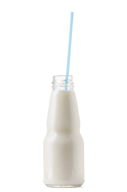 istock Glass cup of milk with a straw isolated on white 1289356159