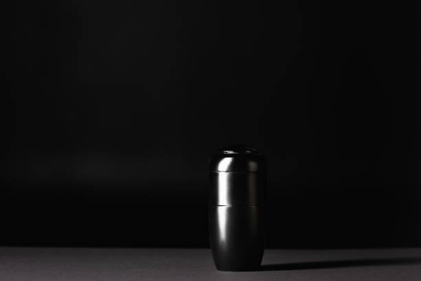 istock urn with ashes on black background, funeral concept 1289357443