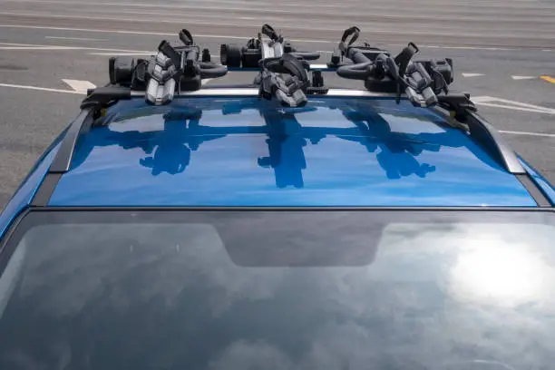 3 bicycle racks mounted on blue car roof.