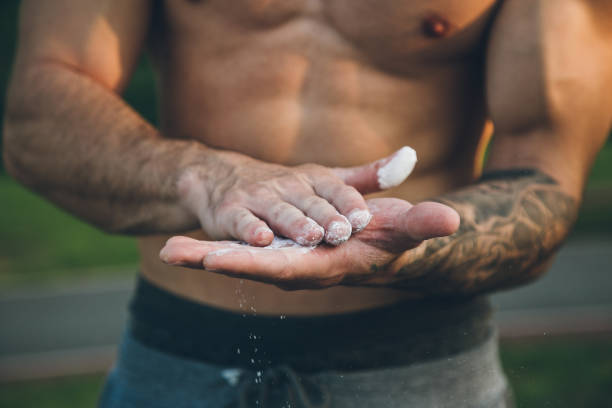 istock Young urban bodybuilder coating his hands with magnesium chalk for calisthenics training 1289359391