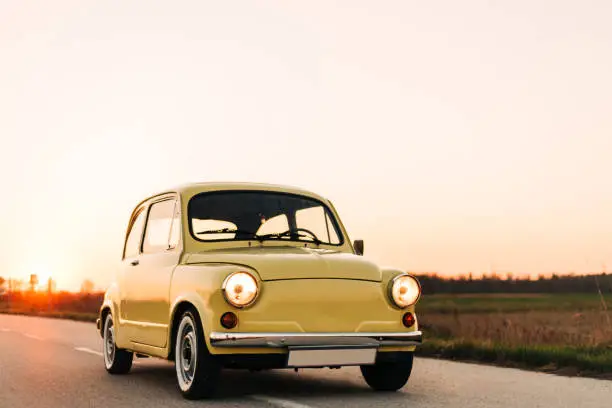 Oldtimer car Fiat 500 (Zastava), cute yellow car photo shoot during the sunset.