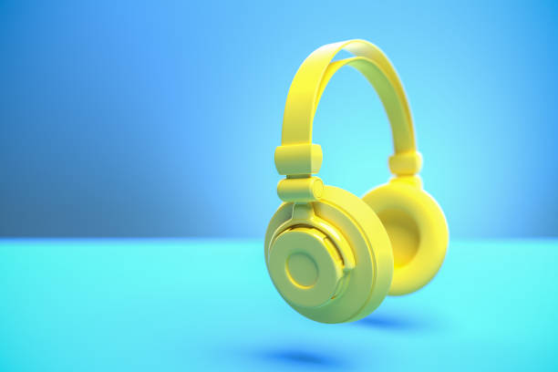 istock Music concept: A yellow headphone against a blue background with shadow. Copy space - selective focus on foreground 1289360227