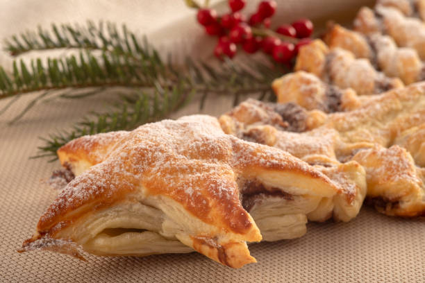 Christmas tree made of puff pastry filled with chocolate cream. Homemade with Christmas decoration.