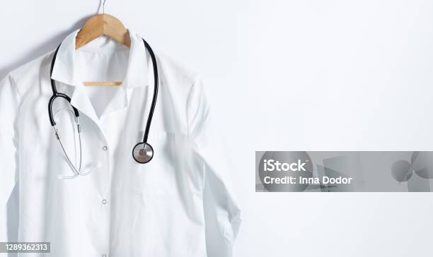 Doctors White Coat With Stethoscope On Hanger Over White Background With Copy Space Stock Photo - Download Image Now