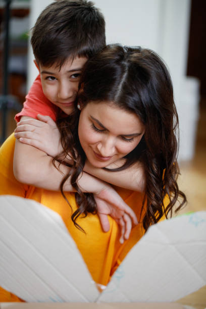 istock Happy boy embracing his mother from the back and looking at camera 1289363765