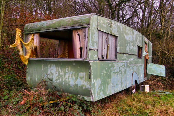 An abandoned caravan, with the interior completely smashed and ruined.