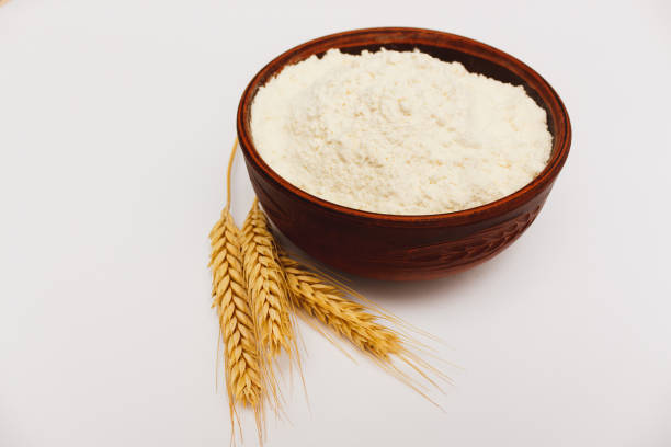 istock White flour in brown bowl and spikelets on white background. Ingredients for cooking 1289365592